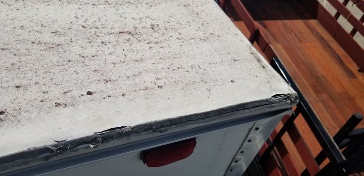 Worn RV roof shown with leaking seam