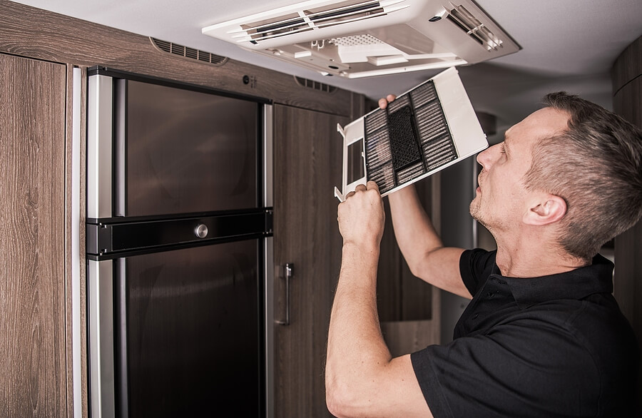 Man doing maintenance on his RV air conditioning unit