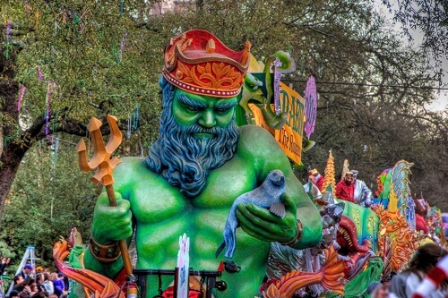 RV Masters Guide to Celebrating Mardi Gras 2021 in Kenner, LA: Colorful Poseidon Float during Mardis Gras Parade with people throwing beads