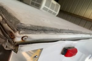 RV Masters: Why It's Important To Have Your RV Roof Inspected By A Professional in Kenner, LA. Close up image of damaged RV roof in shop