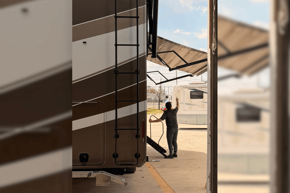 RV safety inspection in LaPlace, LA by RV Masters. Image of a technician opening an RV awning inside a service bay during inspection. Highlighting thorough system checks, structural safety, and reliable performance for worry-free travel.